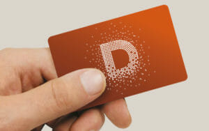Hand holding an orange museum membership card with