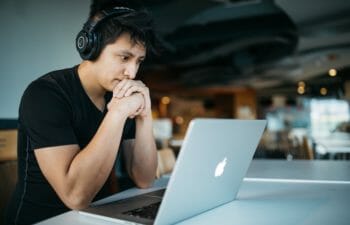 Person with headphones on looking at laptop