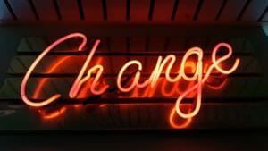 A neon sign that reads "Change" against a black background