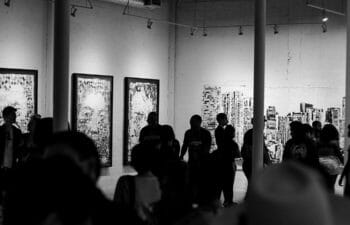 Black and white photo of a crowded art gallery