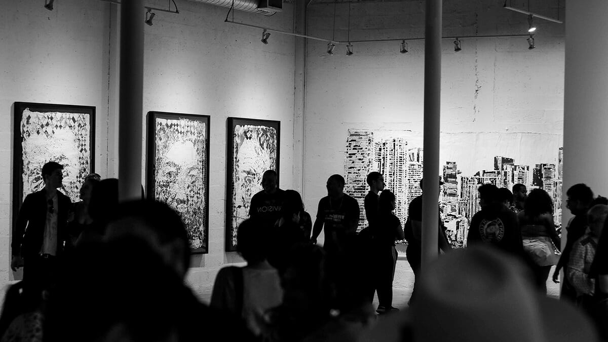 Black and white photo of a crowded art gallery