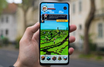 Person holding an iPhone with Minecraft on the screen