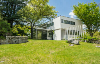 White Bauhaus-style home on a green grassy hill