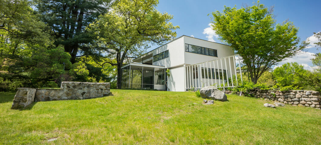 White Bauhaus-style home on a green grassy hill