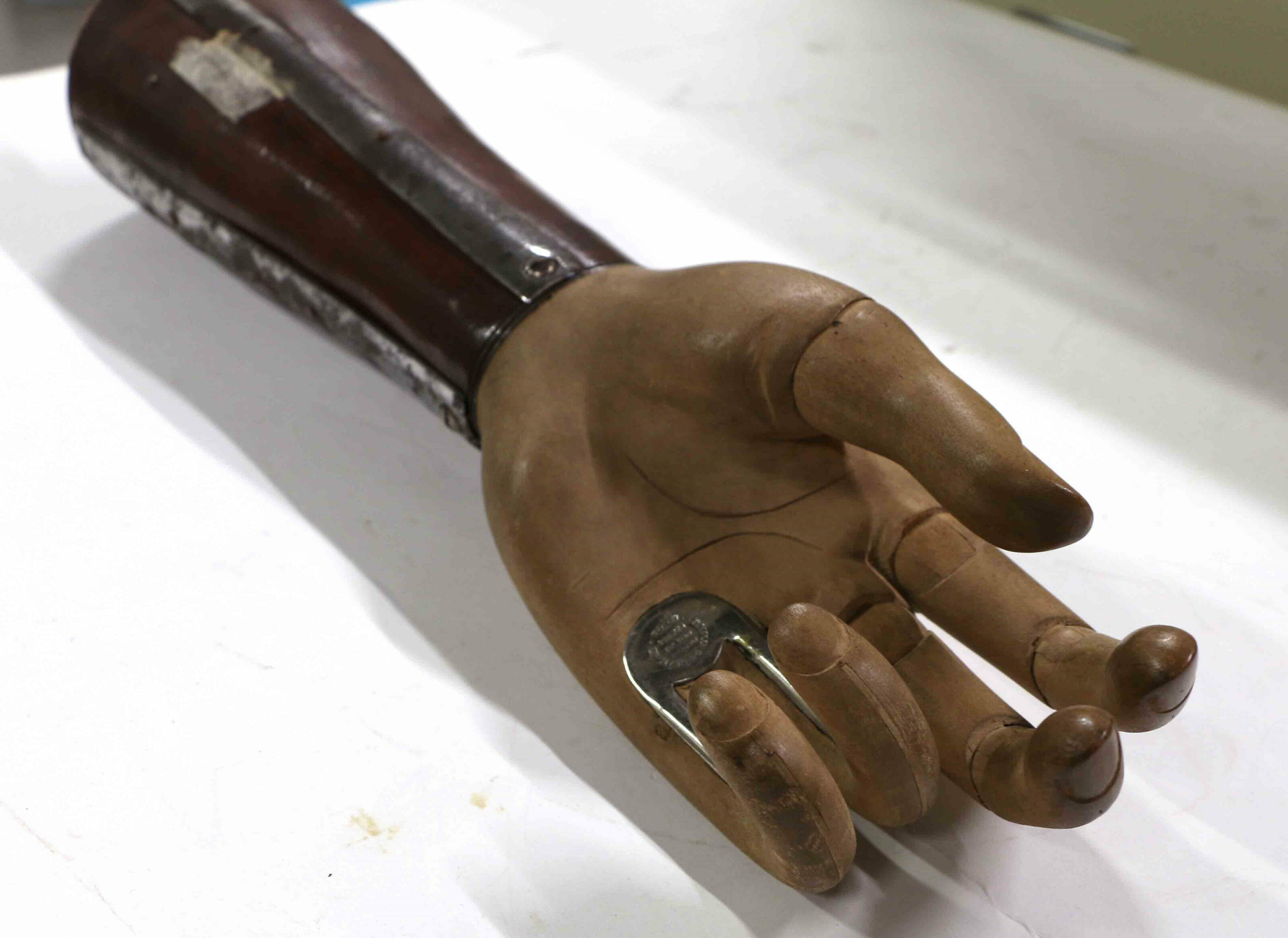 Openshaw wooden artificial hand. Designed by Thomas Openshaw, a surgeon at Queen Mary's Hospital, Roehampton, during World War I. A special feature of the hand is that the the ring and little fingers are held rigid, in a slightly flexed position, with steel reinforcement which extends into the palm. This allows bags and other objects to be carried. The thumb, index and middle fingers have a certain degree of articulation. Made by Anderson & Whitelaw, England c.1919.