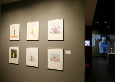 Gallery wall with six Alleles concept drawings on display. Drawings depict people wearing various designs of the Alleles leg covers.